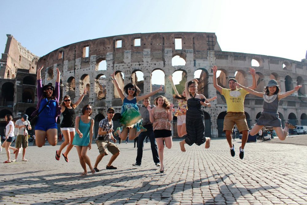 Trainee teachers jumping for joy outside the Colosseum in Rome